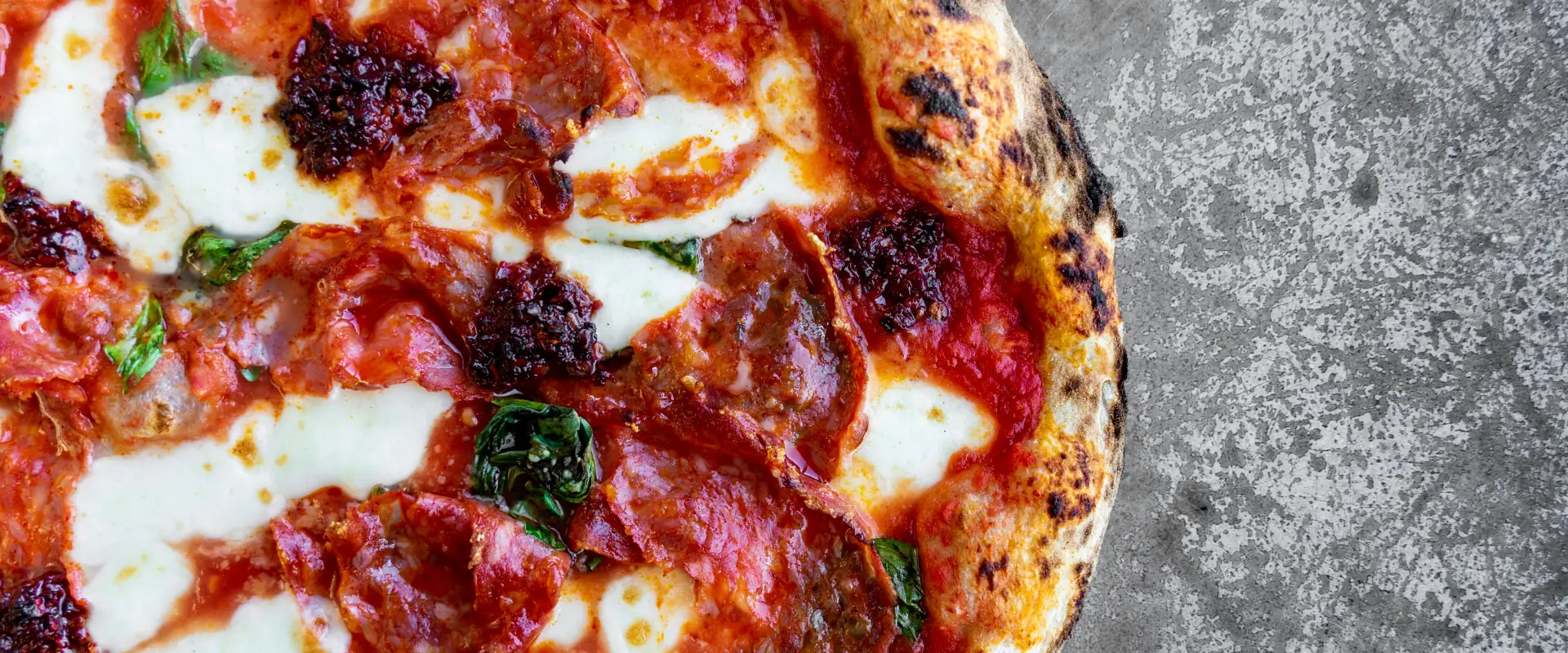 Pizza topped with mozzarella, salami and sauce